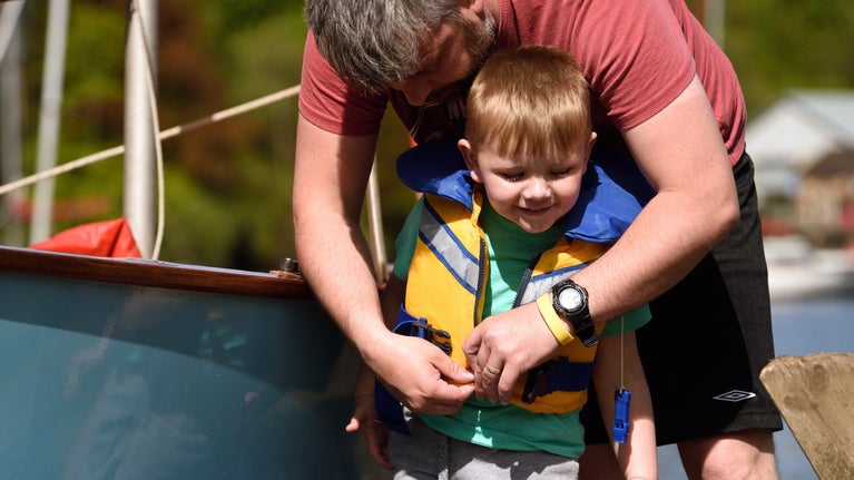 A boy getting fitted for a buoyancy aid at Fell Foot in Windermere